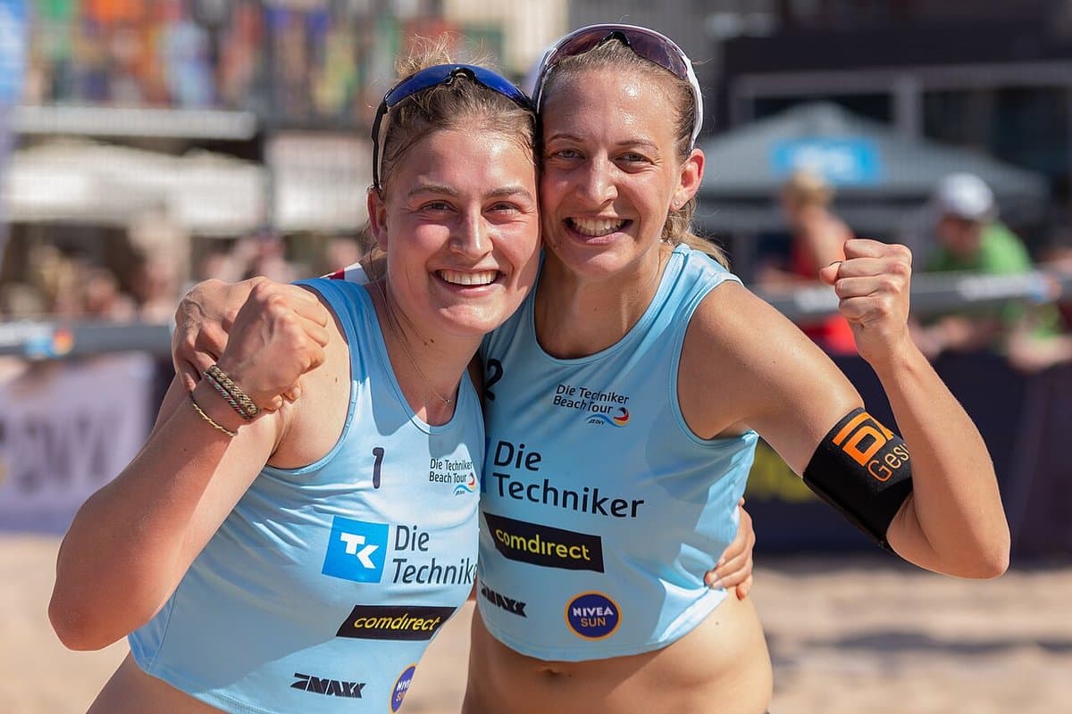 Beach volleyball partners hugging after winning a point