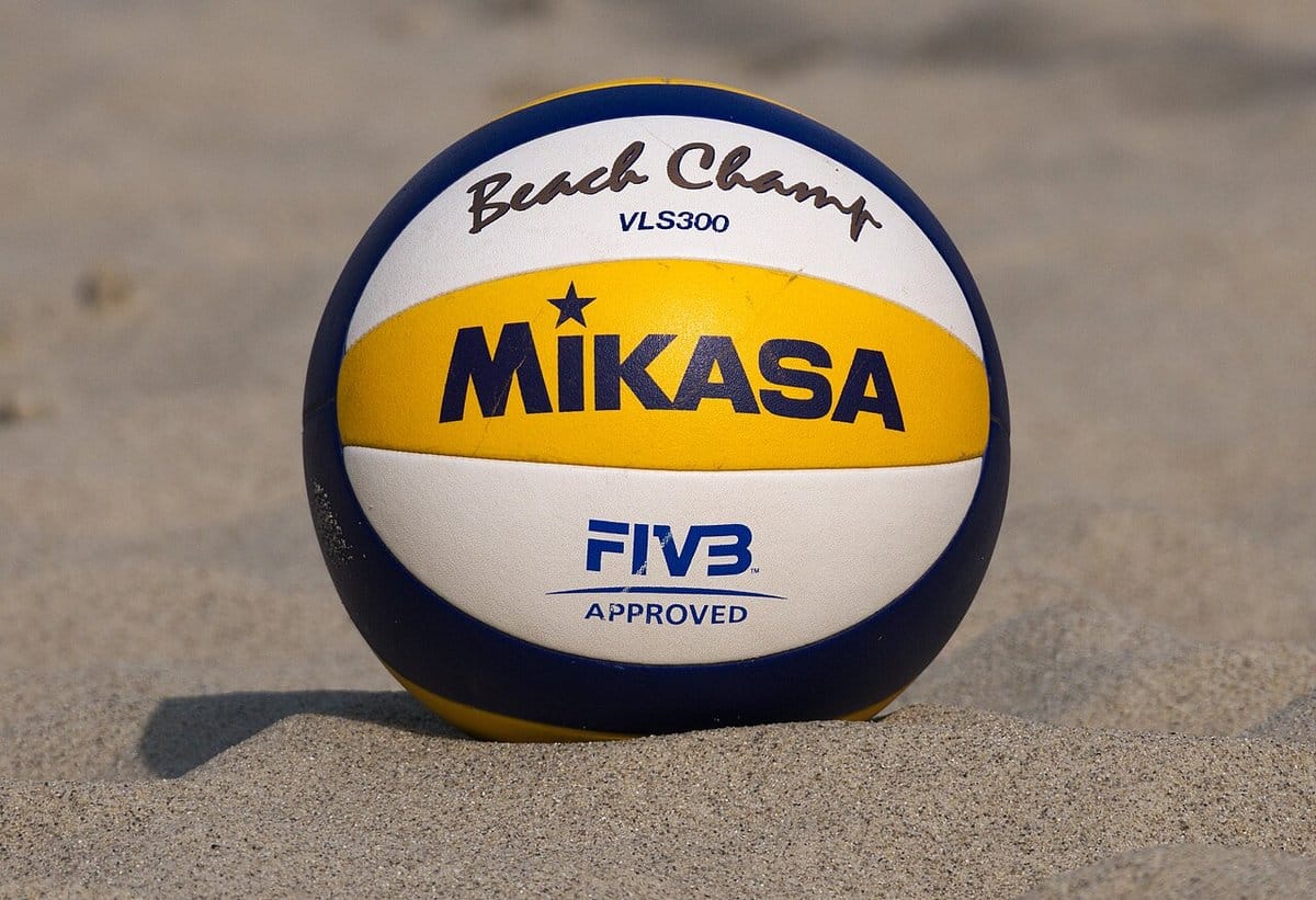 Official beach volleyball resting in the sand