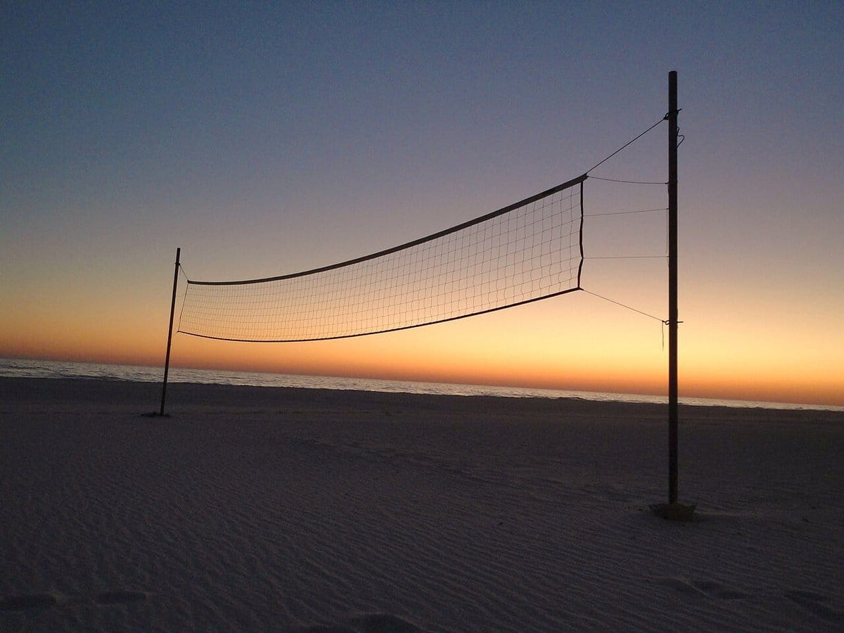 Beach volleyball net silhouetted at sunset