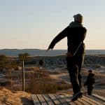 Disc golfer throwing a drive at sunset