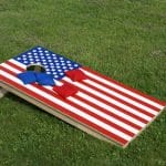 Cornhole board painted with the American flag on a lawn