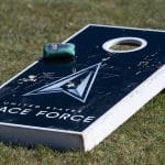Cornhole board with a bag on the grass
