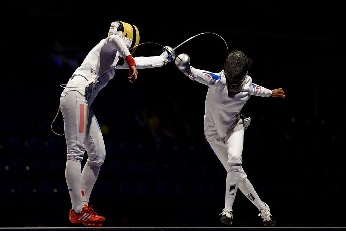 Two epee fencers lunging at each other on the piste
