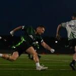 Flag football players racing for the ball at night