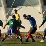Flag football players chasing a runner on a turf field