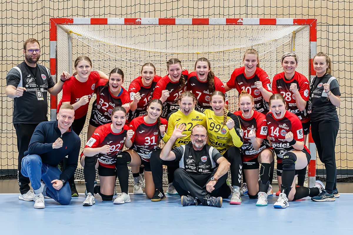 Handball team celebrating together in front of the goal