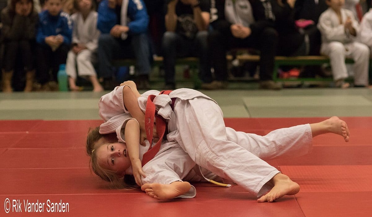 Two young judoka grappling at a youth tournament