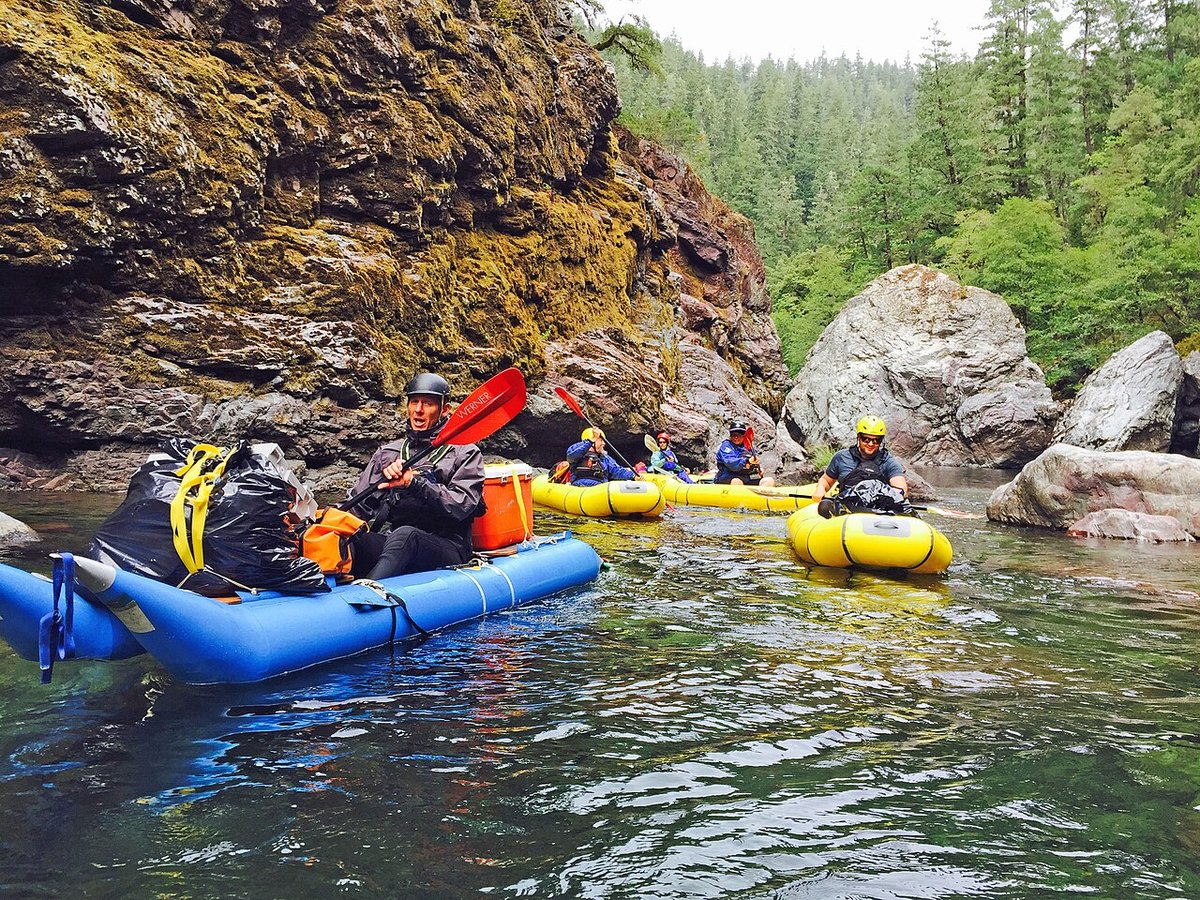 Group of kayakers and rafters on a forest river