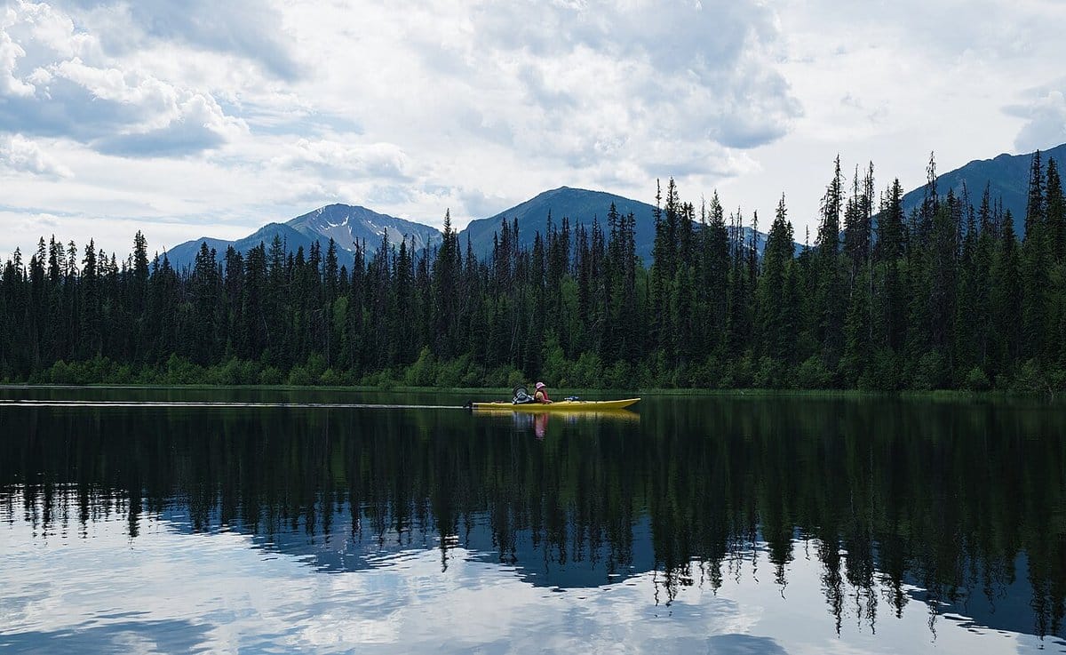 Kayaker gliding across a calm mountain lake