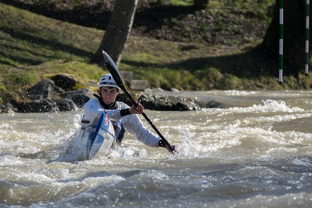 Kayaker paddling through whitewater on a fast river