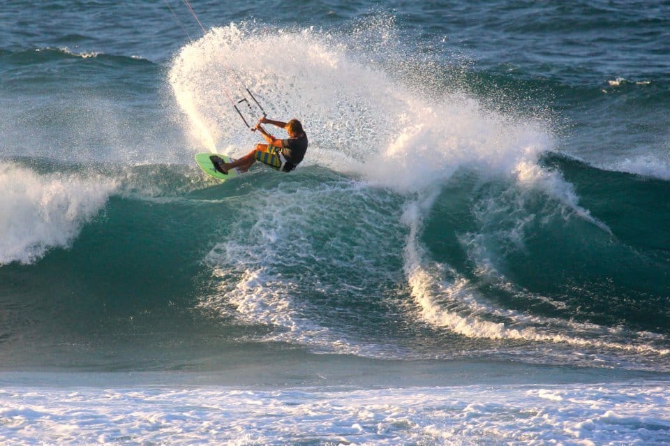 Kitesurfer carving off the lip of a breaking wave