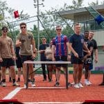 Players lined up behind cornhole boards at a competition