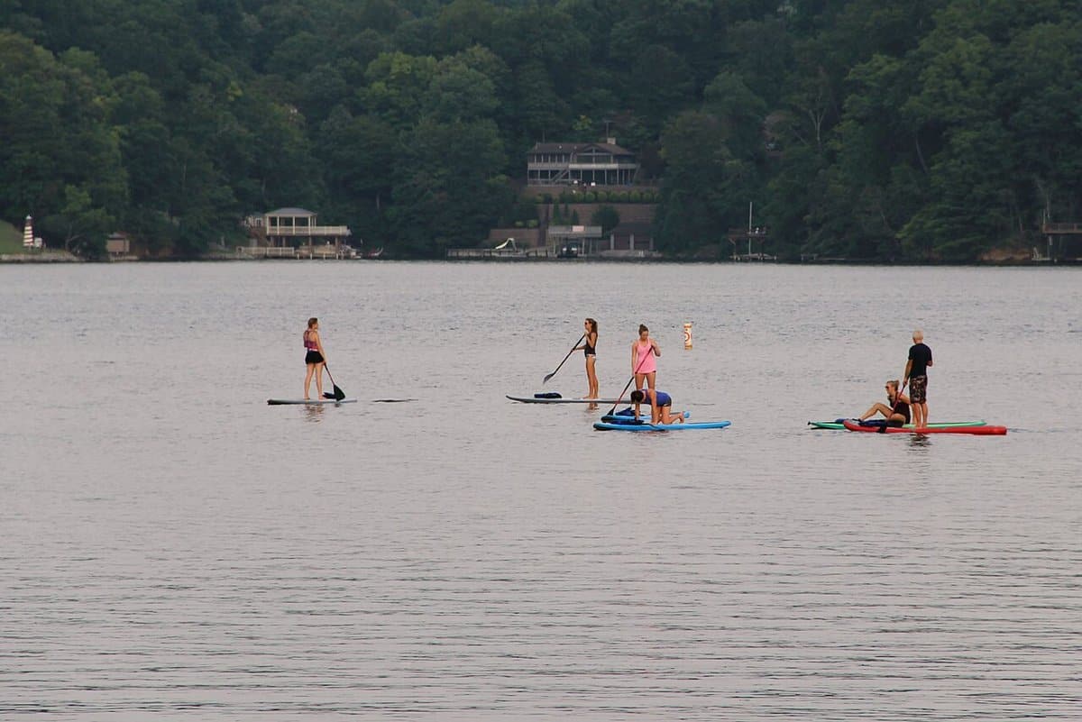 Group doing SUP yoga together on a lake