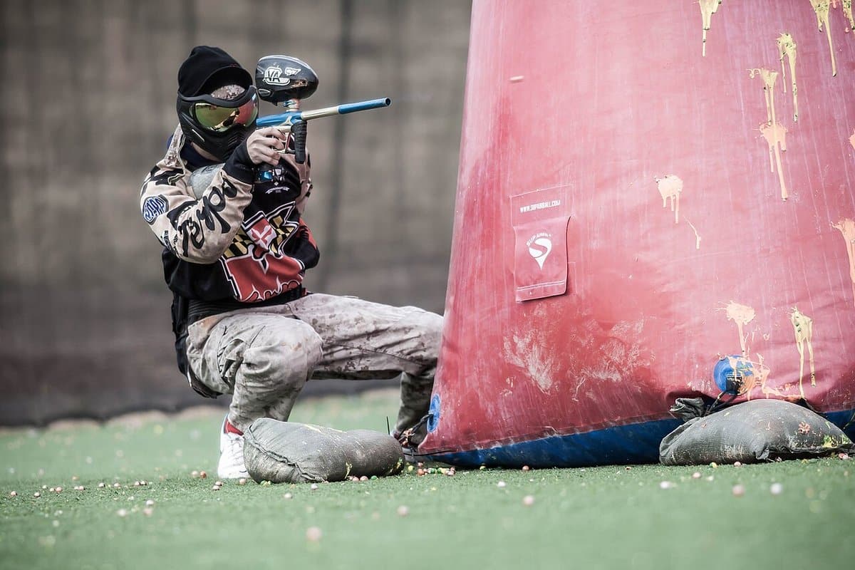 Paintball player crouched behind an inflatable bunker