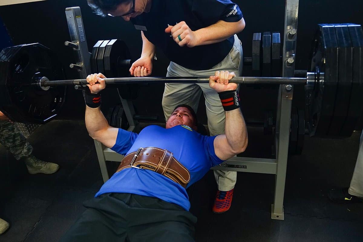Lifter pressing a loaded barbell on the bench