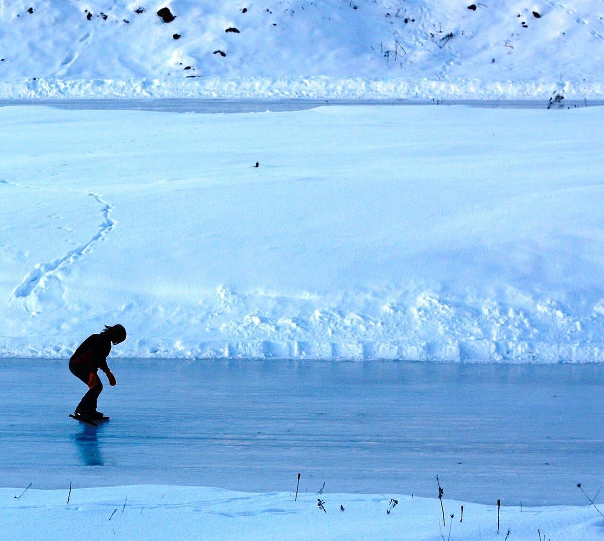 Lone skater on a frozen outdoor oval