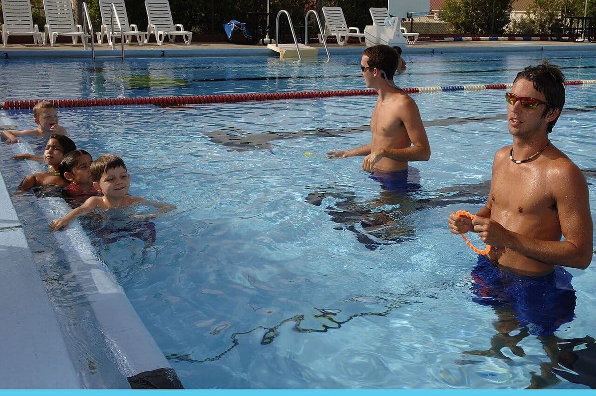 Swim instructors teaching children in a pool