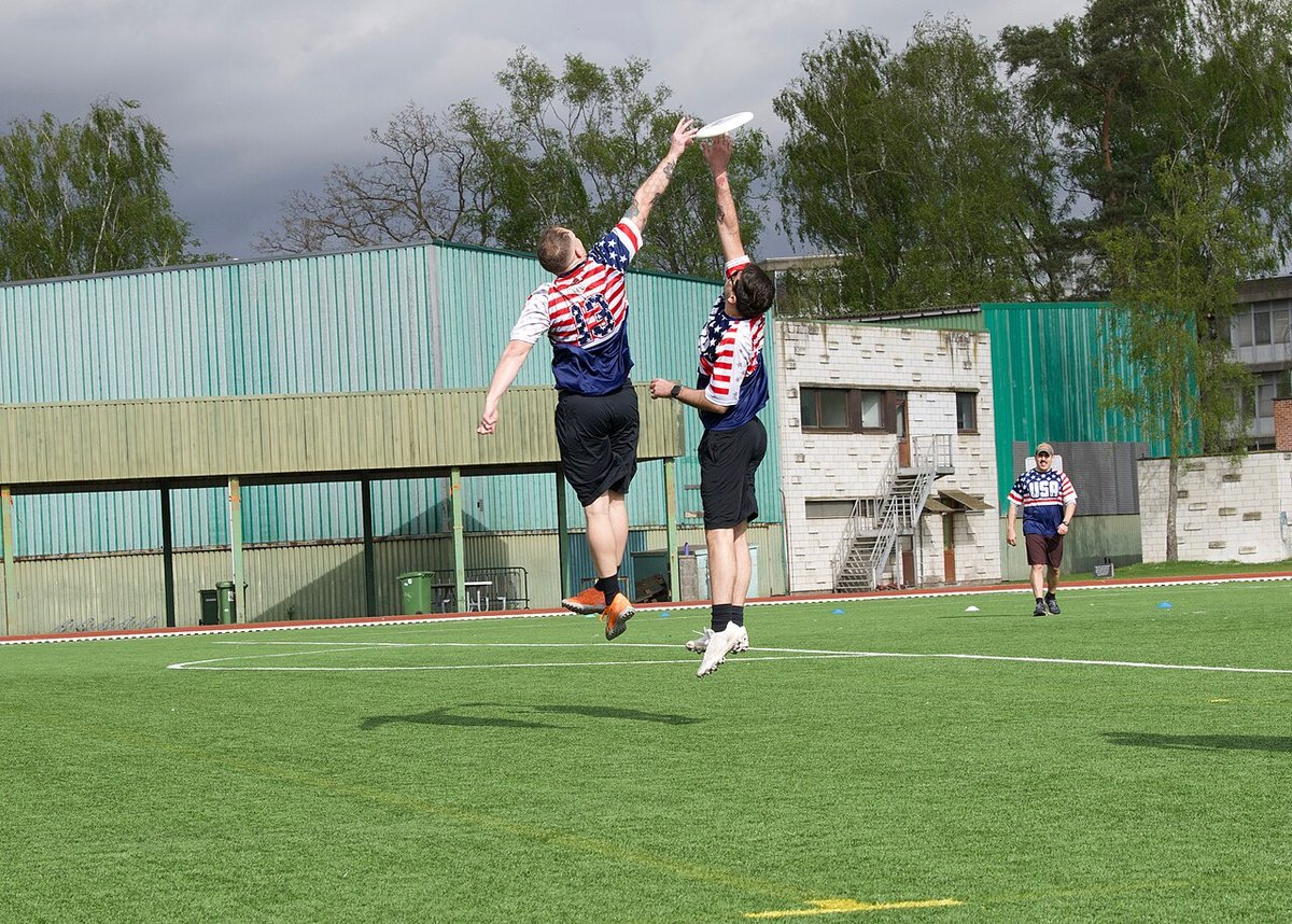 Two players leaping for the disc in an ultimate frisbee game