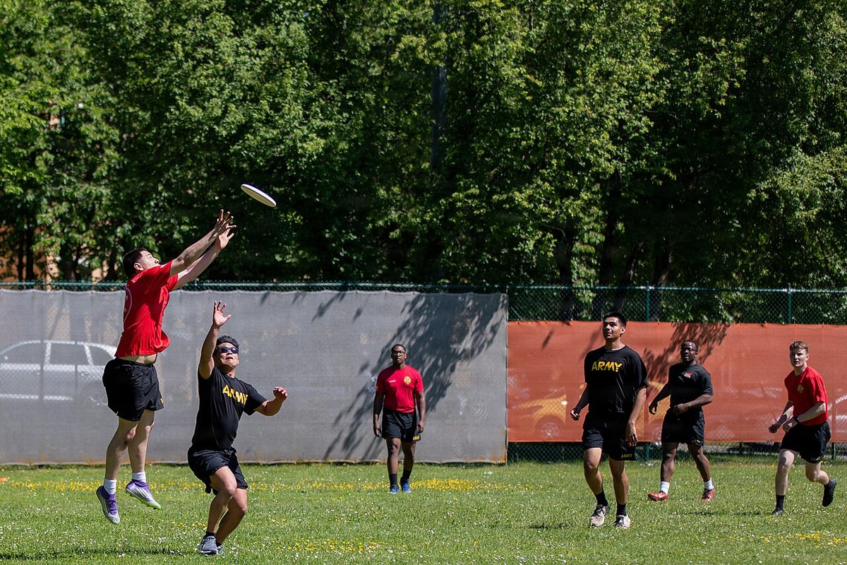 Ultimate frisbee teams running down the field on grass