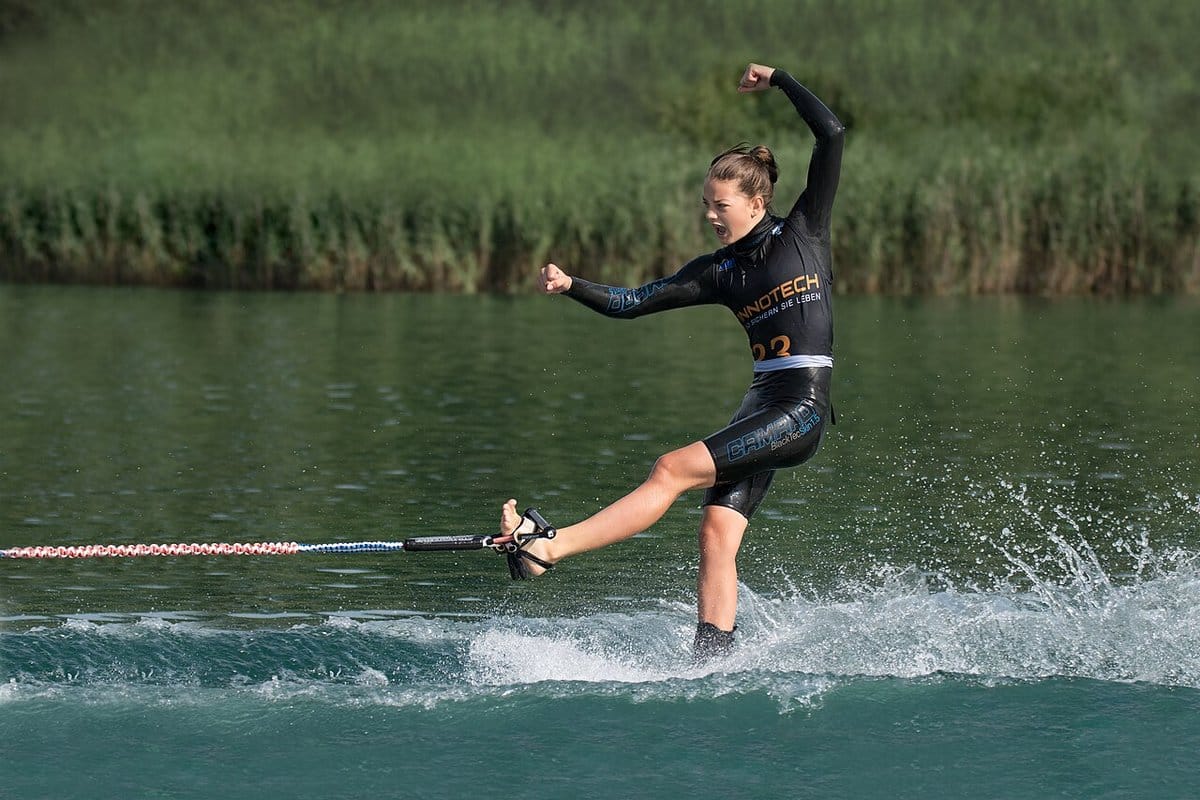 Water skier spraying a wall of water on a trick ski