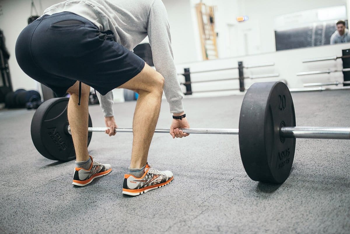 Man setting up for a deadlift with plates on the bar