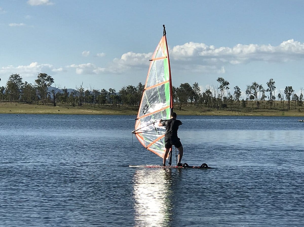 Windsurfer cruising on calm lake water